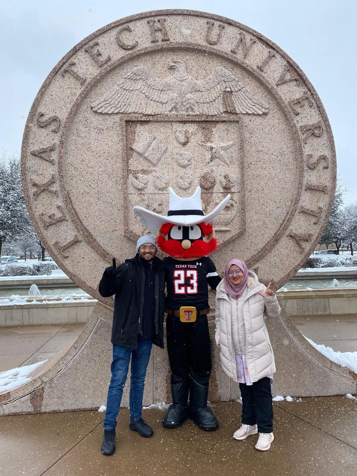M. R. Hoque with the Texas Tech mascot at the university seal in the snow